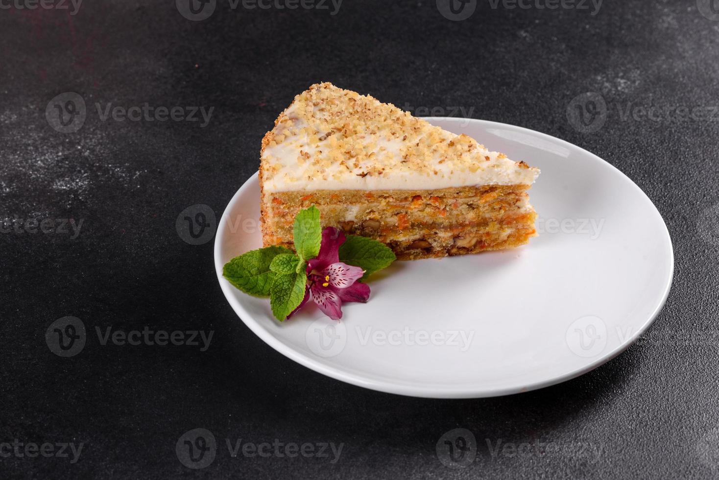 Fresh delicious carrot cake with cream on a dark background photo