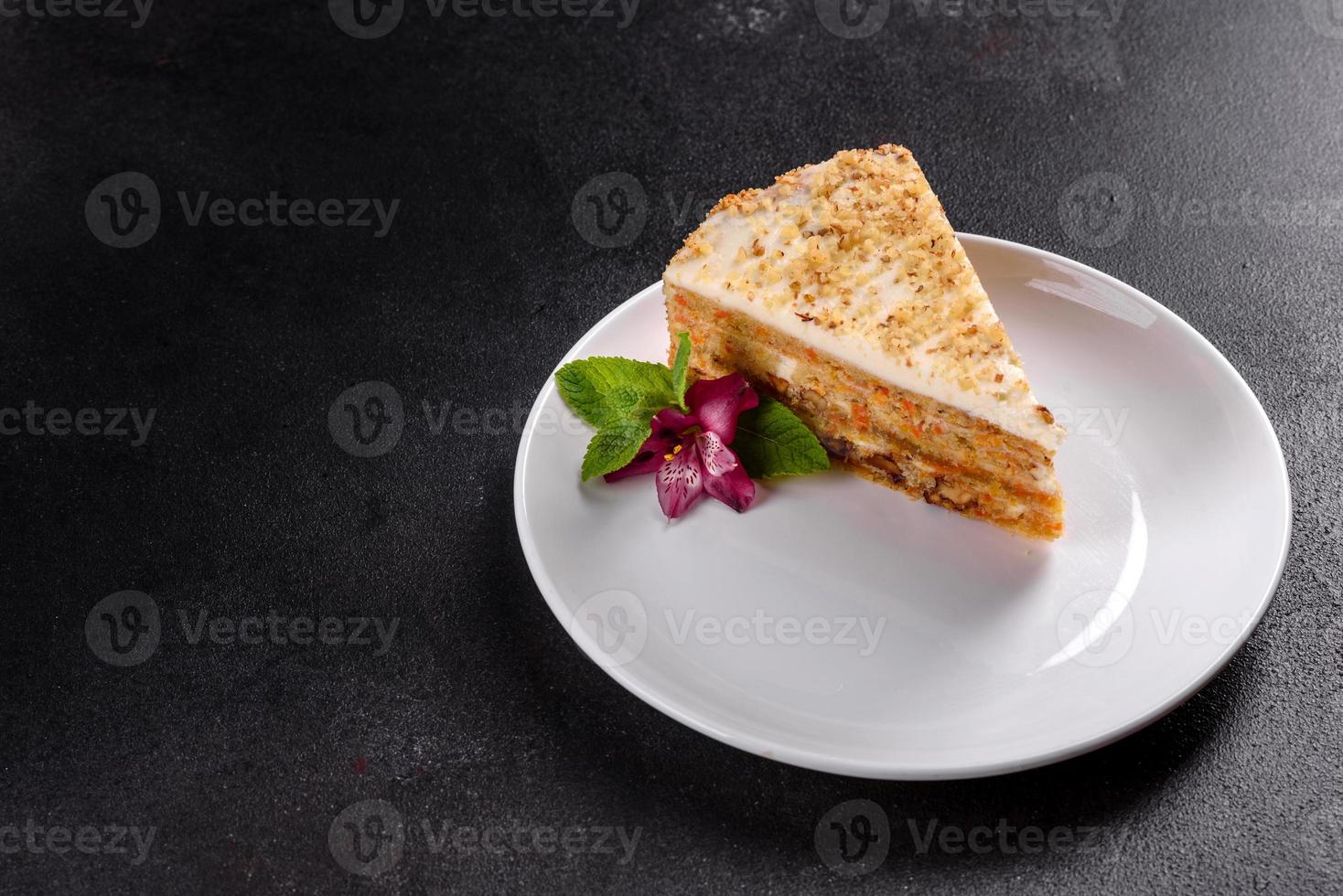 Fresh delicious carrot cake with cream on a dark background photo