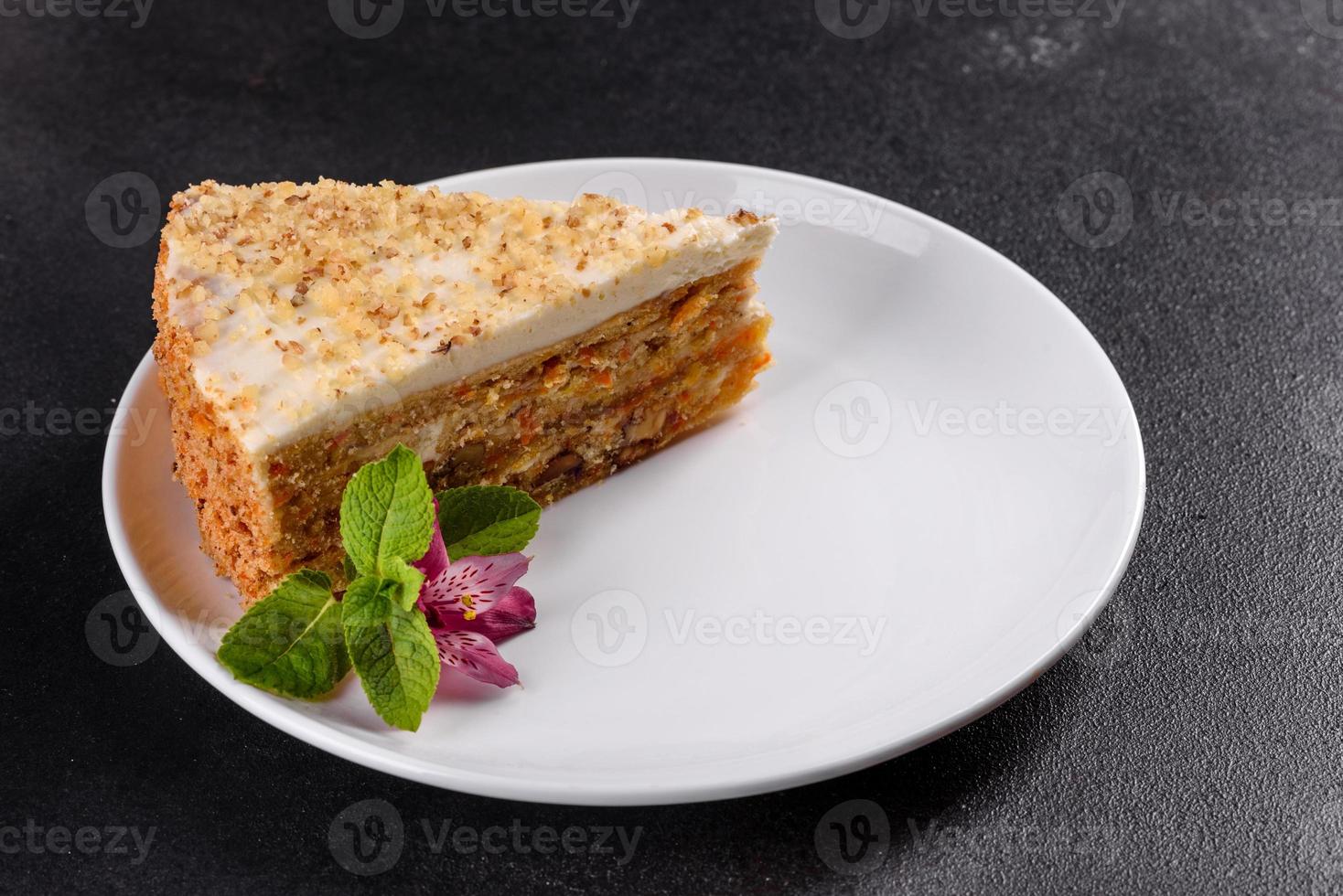 Fresh delicious carrot cake with cream on a dark background photo