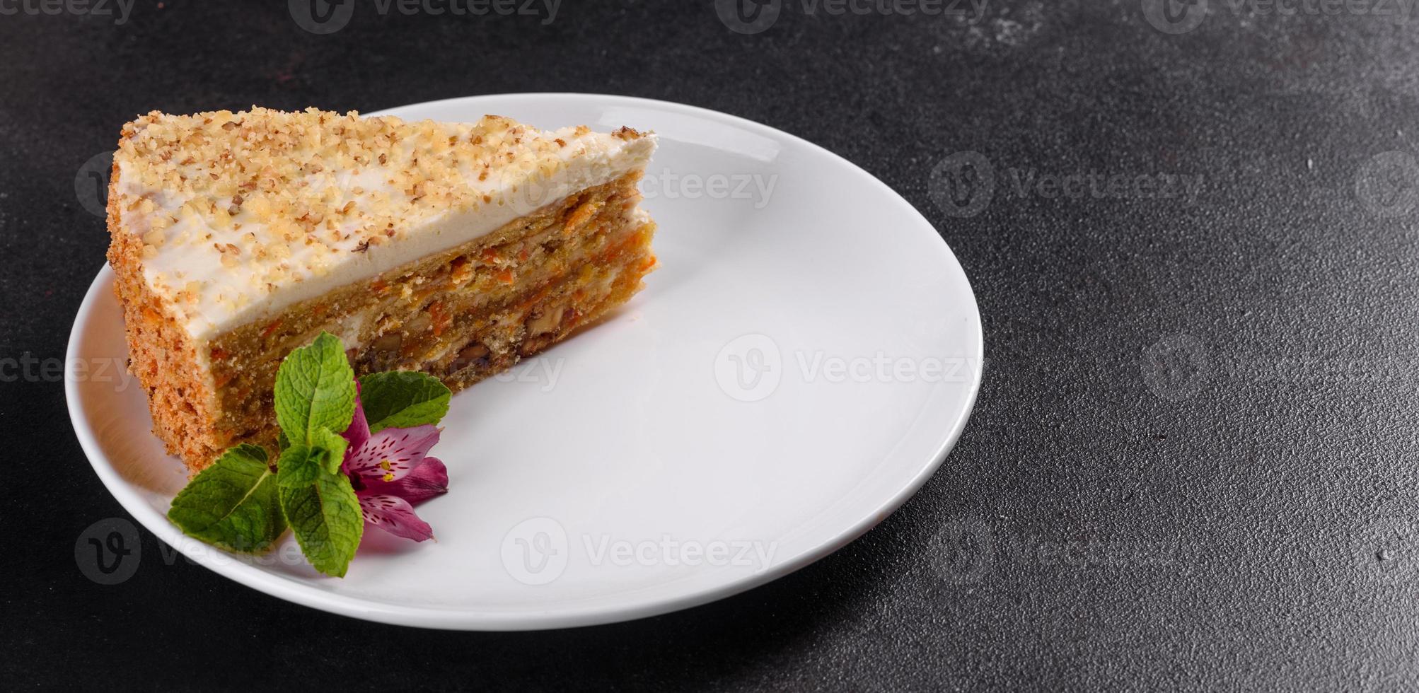 Fresh delicious carrot cake with cream on a dark background photo