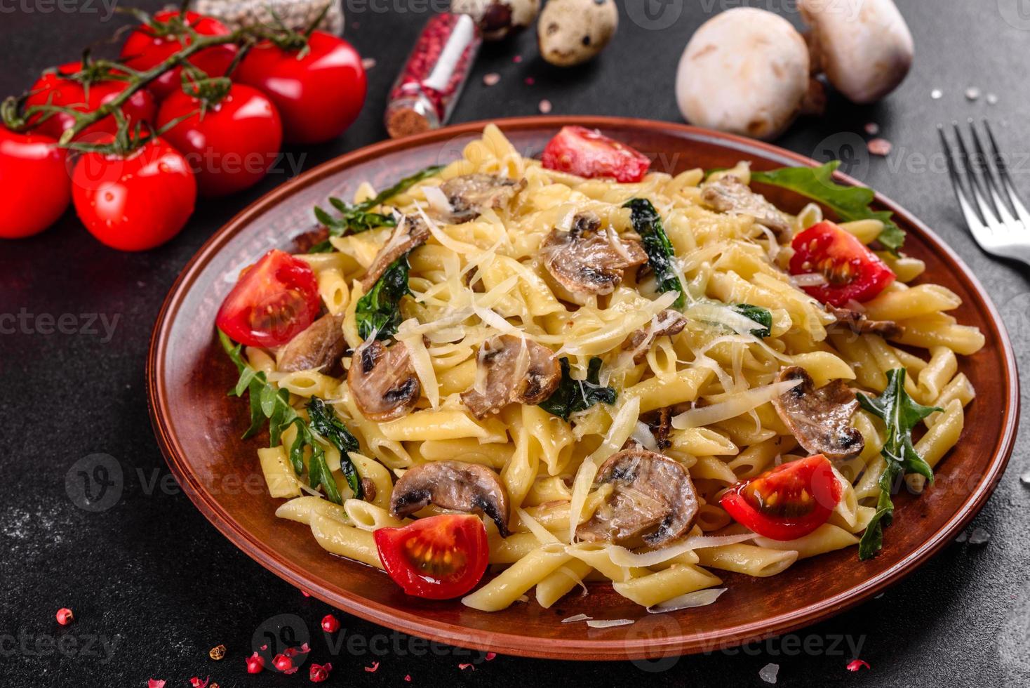 Pasta with mushrooms, cheese, spinach, rukkola and cherry tomatoes photo