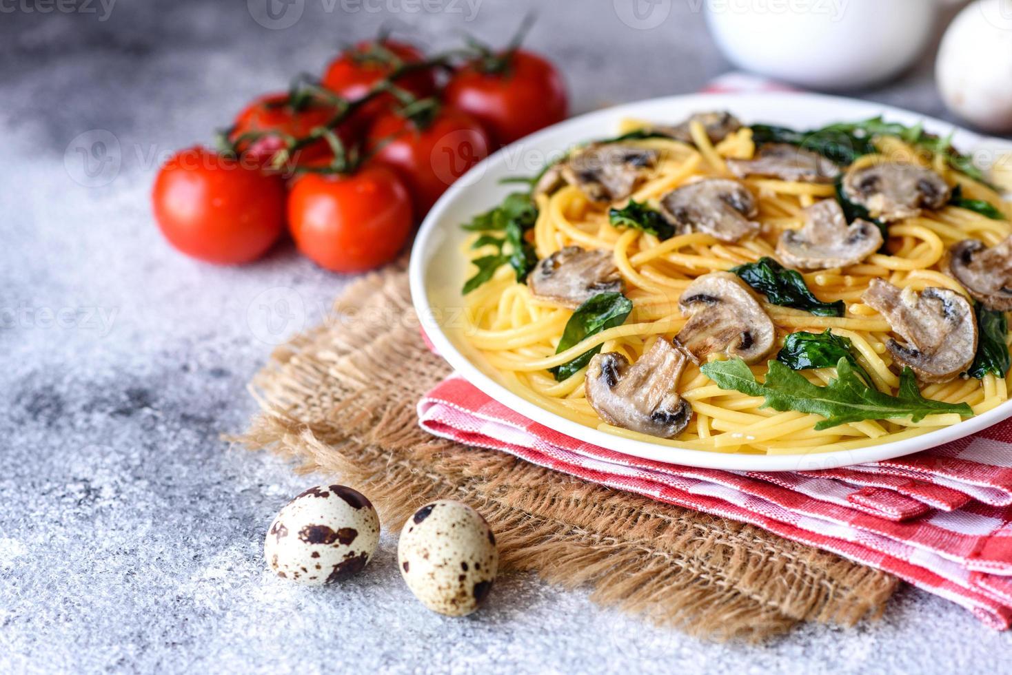 Spaghetti with mushrooms, cheese, spinach, rukkola and cherry tomatoes photo