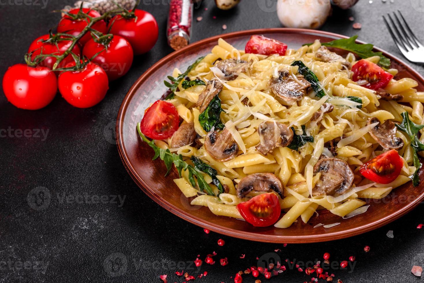 pasta con champiñones, queso, espinacas, rukkola y tomates cherry foto