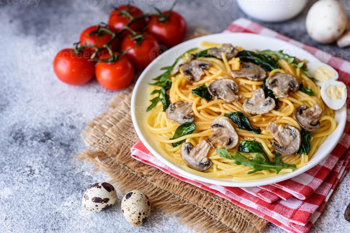 espaguetis con champiñones, queso, espinacas, rukkola y tomates cherry foto