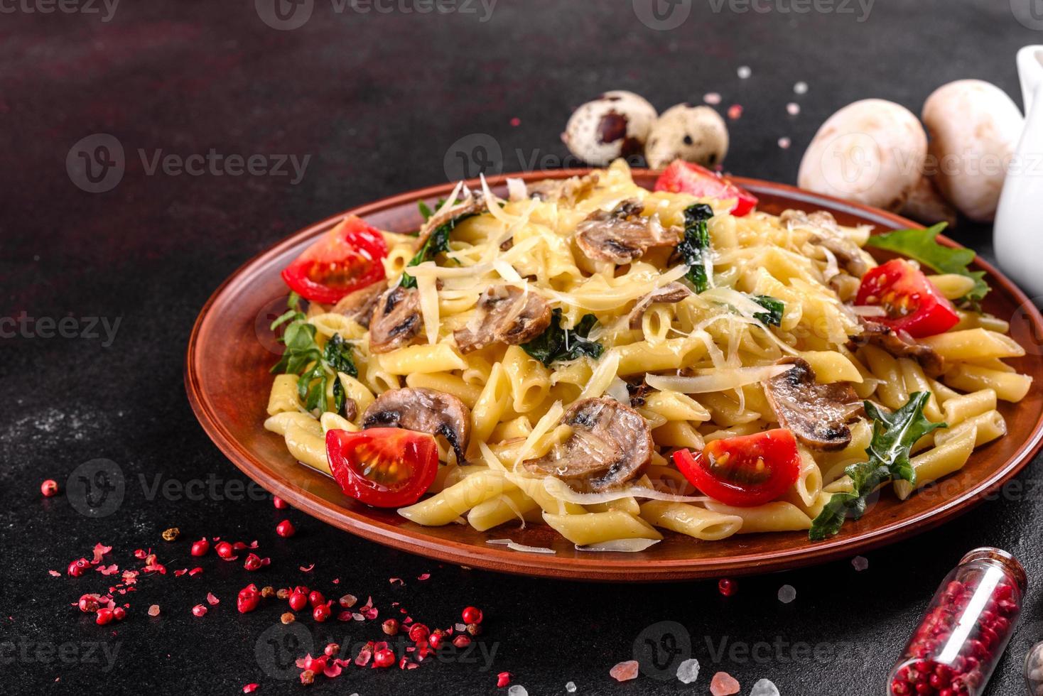 pasta con champiñones, queso, espinacas, rukkola y tomates cherry foto