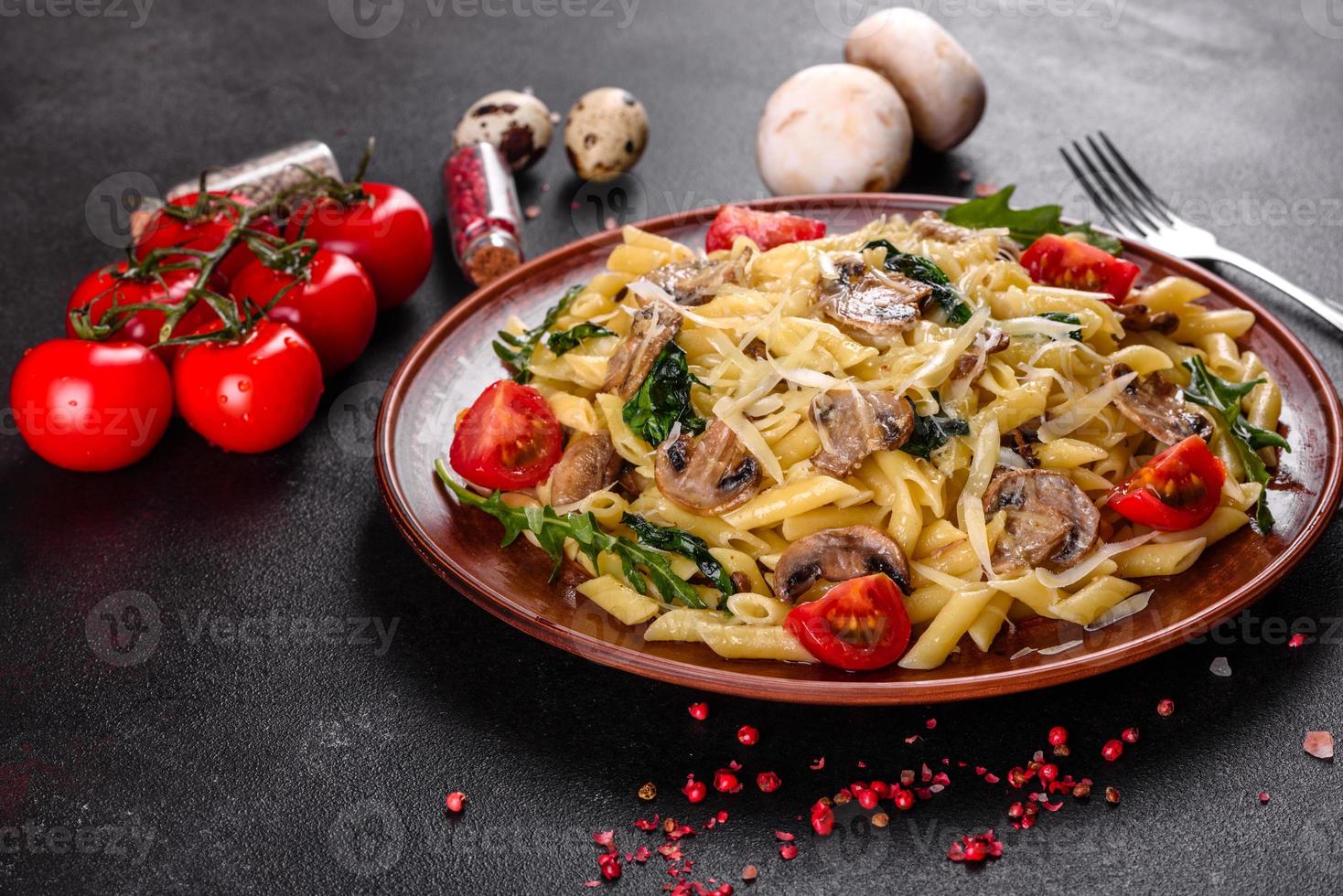 Pasta with mushrooms, cheese, spinach, rukkola and cherry tomatoes photo