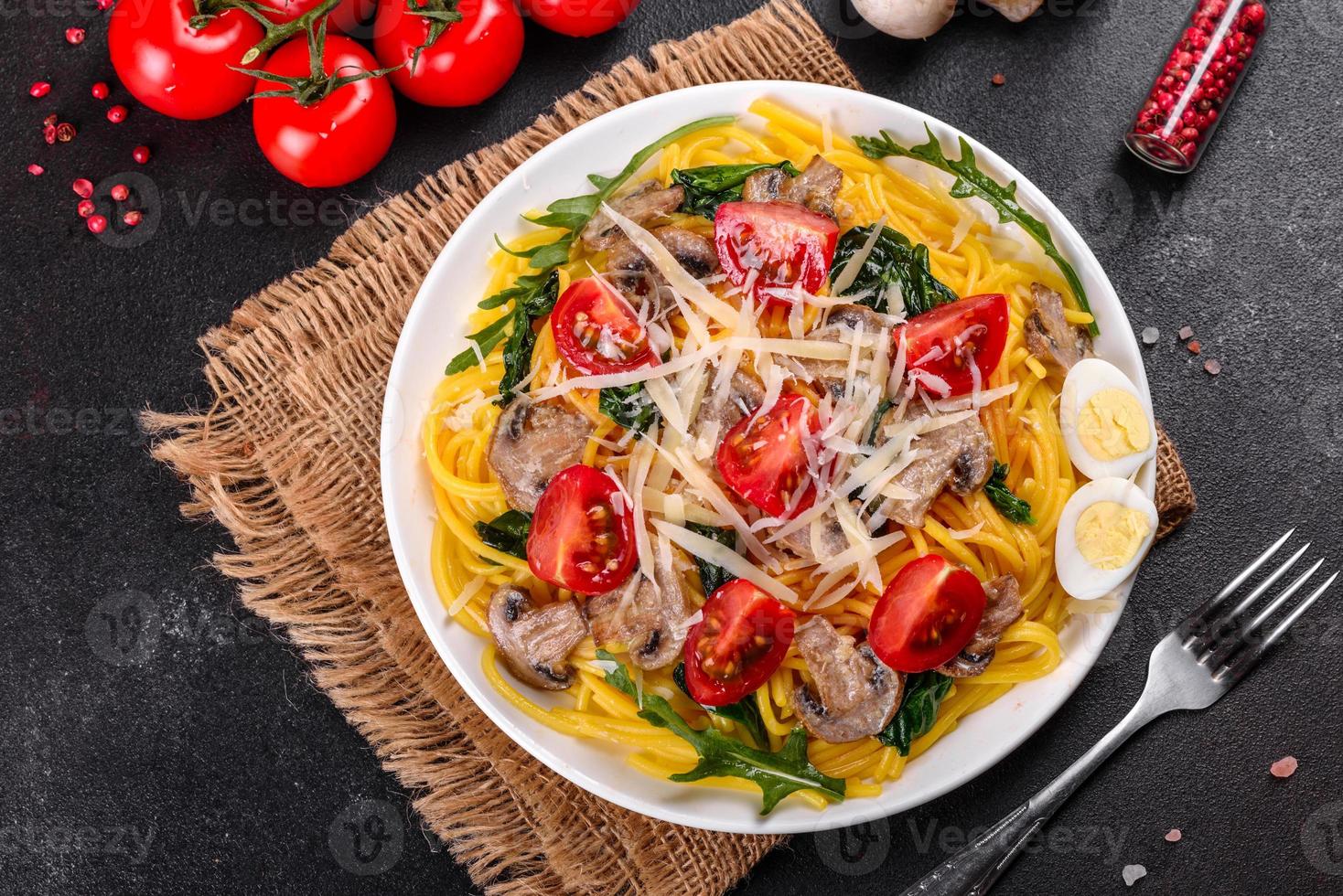 Spaghetti with mushrooms, cheese, spinach, rukkola and cherry tomatoes photo