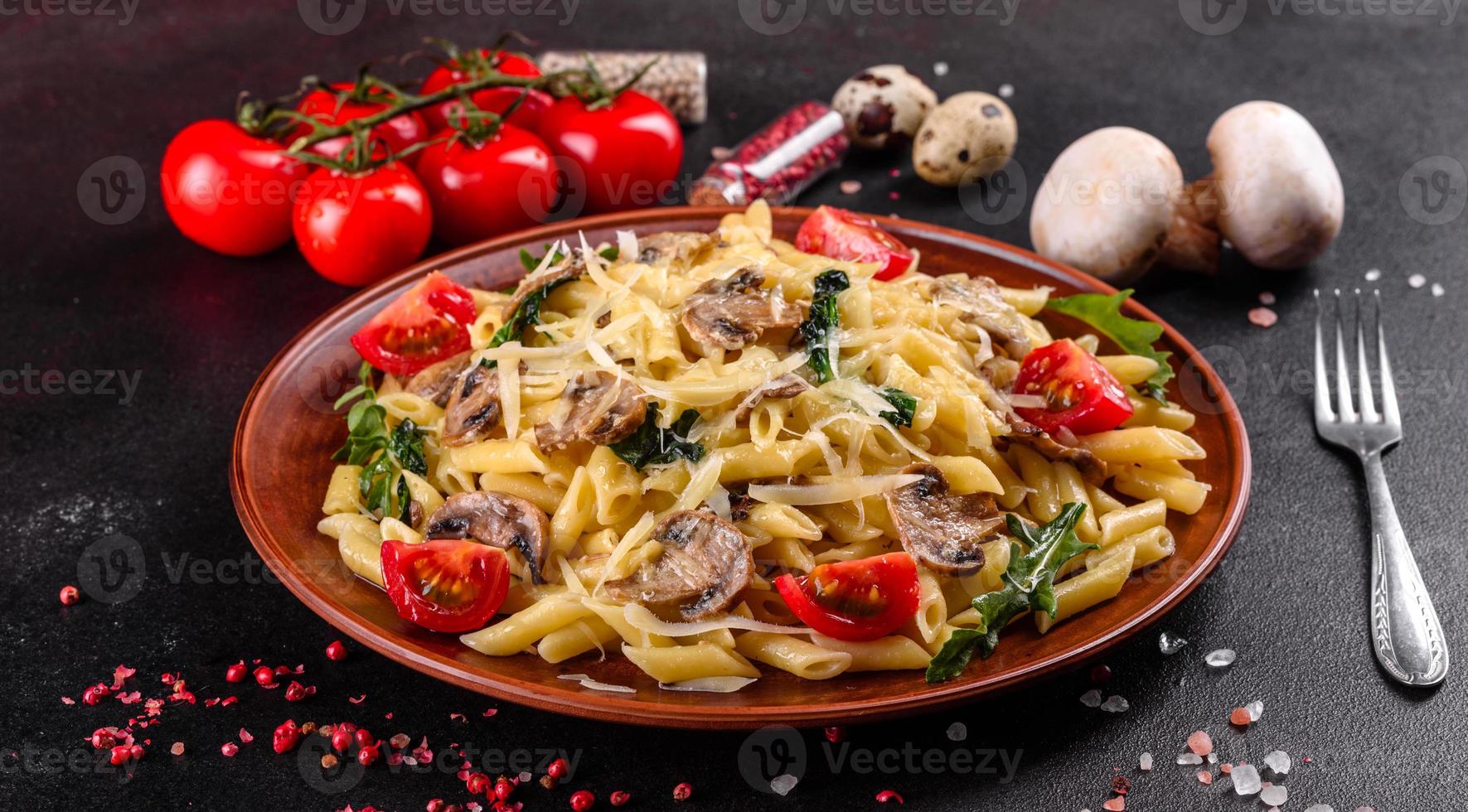 Pasta with mushrooms, cheese, spinach, rukkola and cherry tomatoes photo