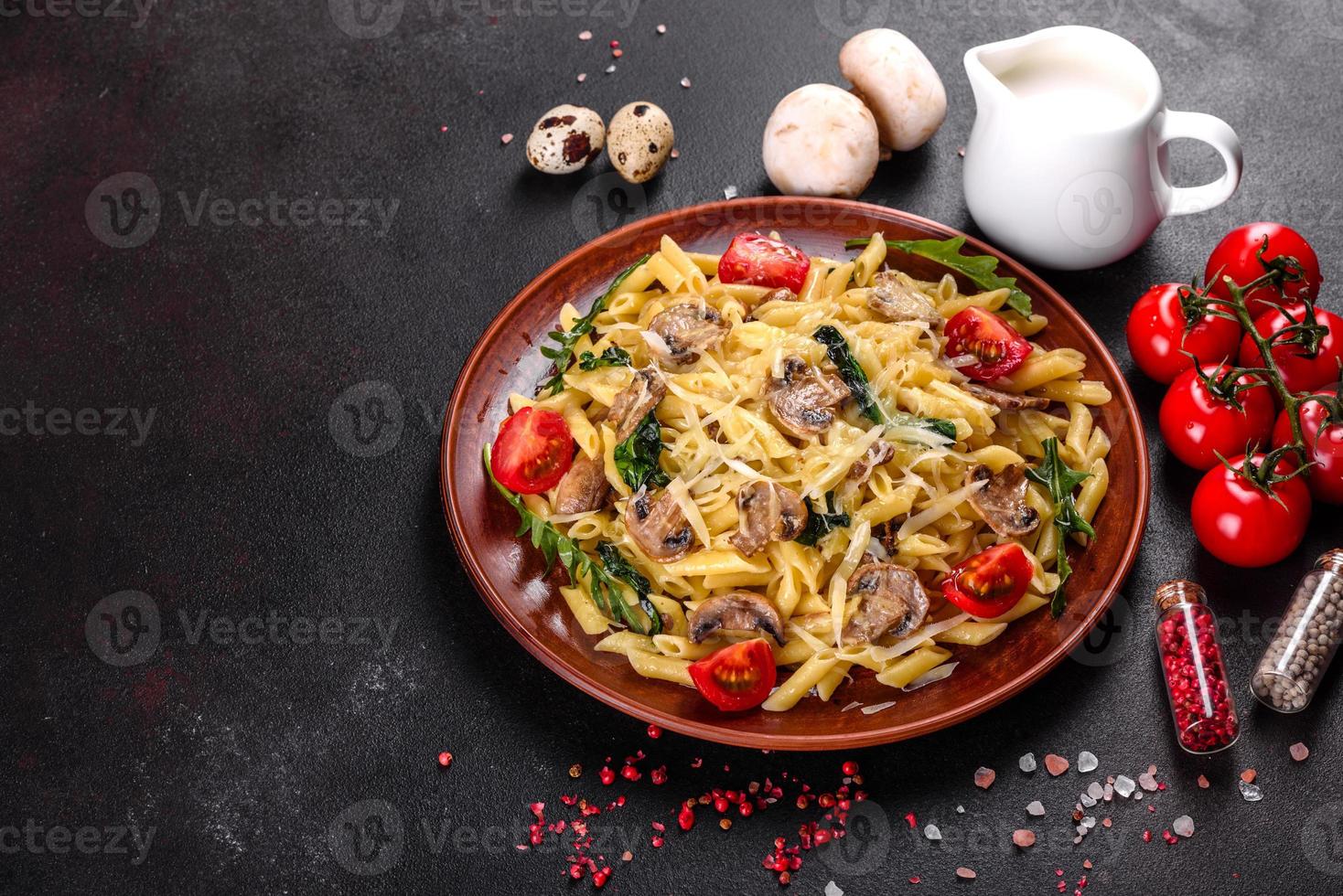 Pasta with mushrooms, cheese, spinach, rukkola and cherry tomatoes photo