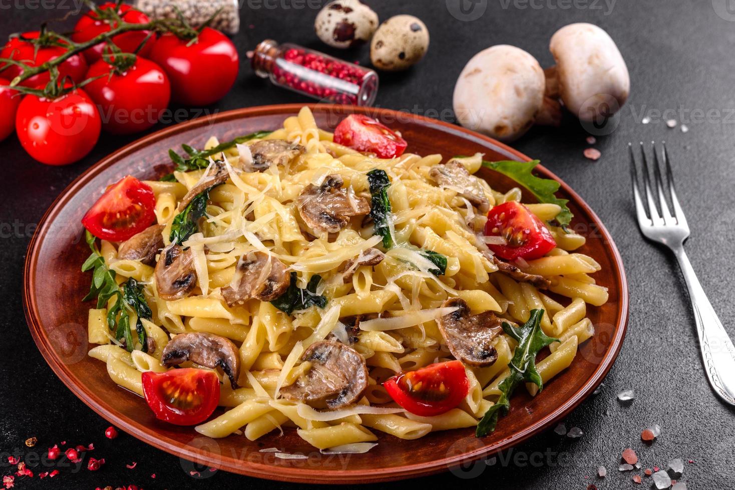 Pasta with mushrooms, cheese, spinach, rukkola and cherry tomatoes photo