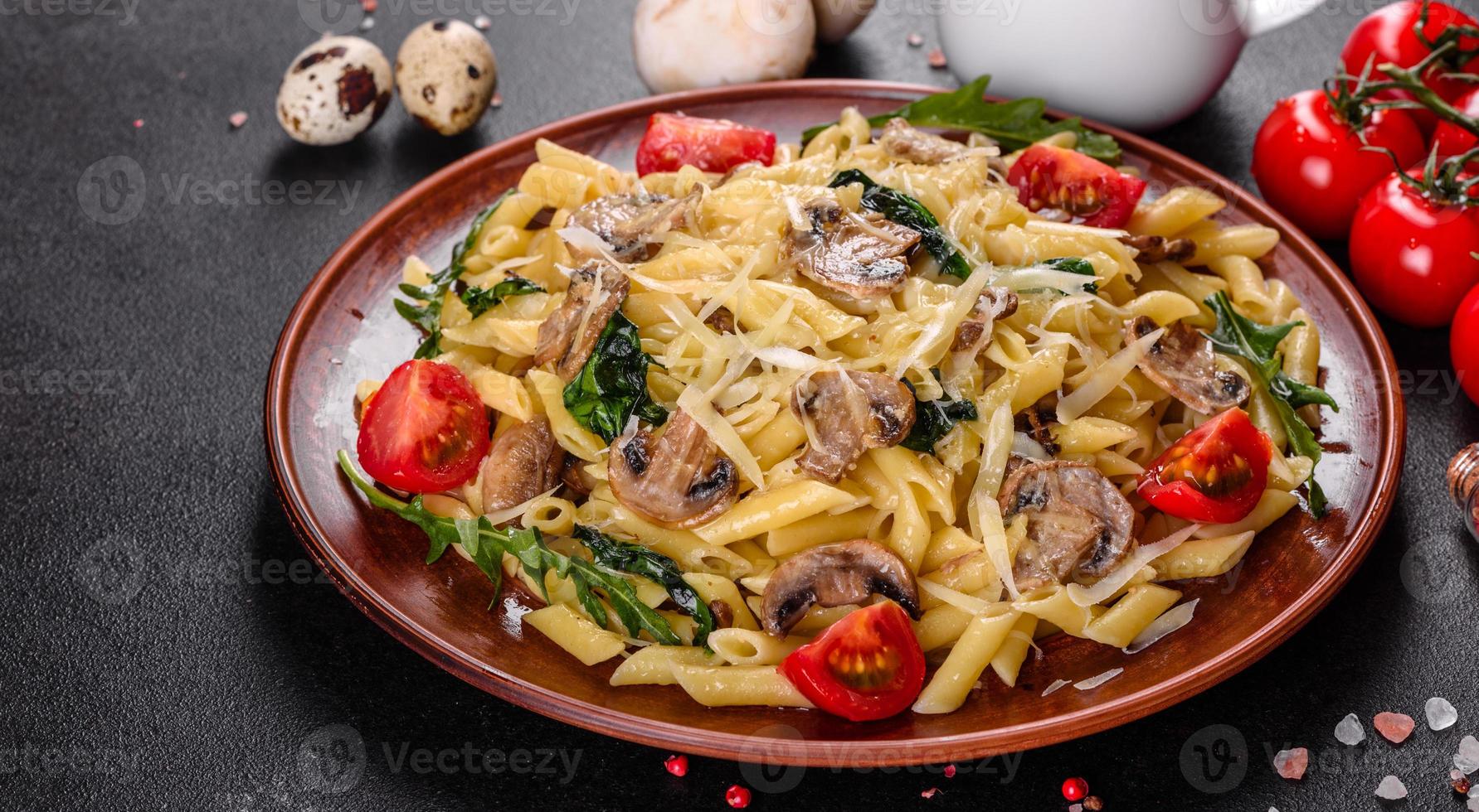 Pasta with mushrooms, cheese, spinach, rukkola and cherry tomatoes photo