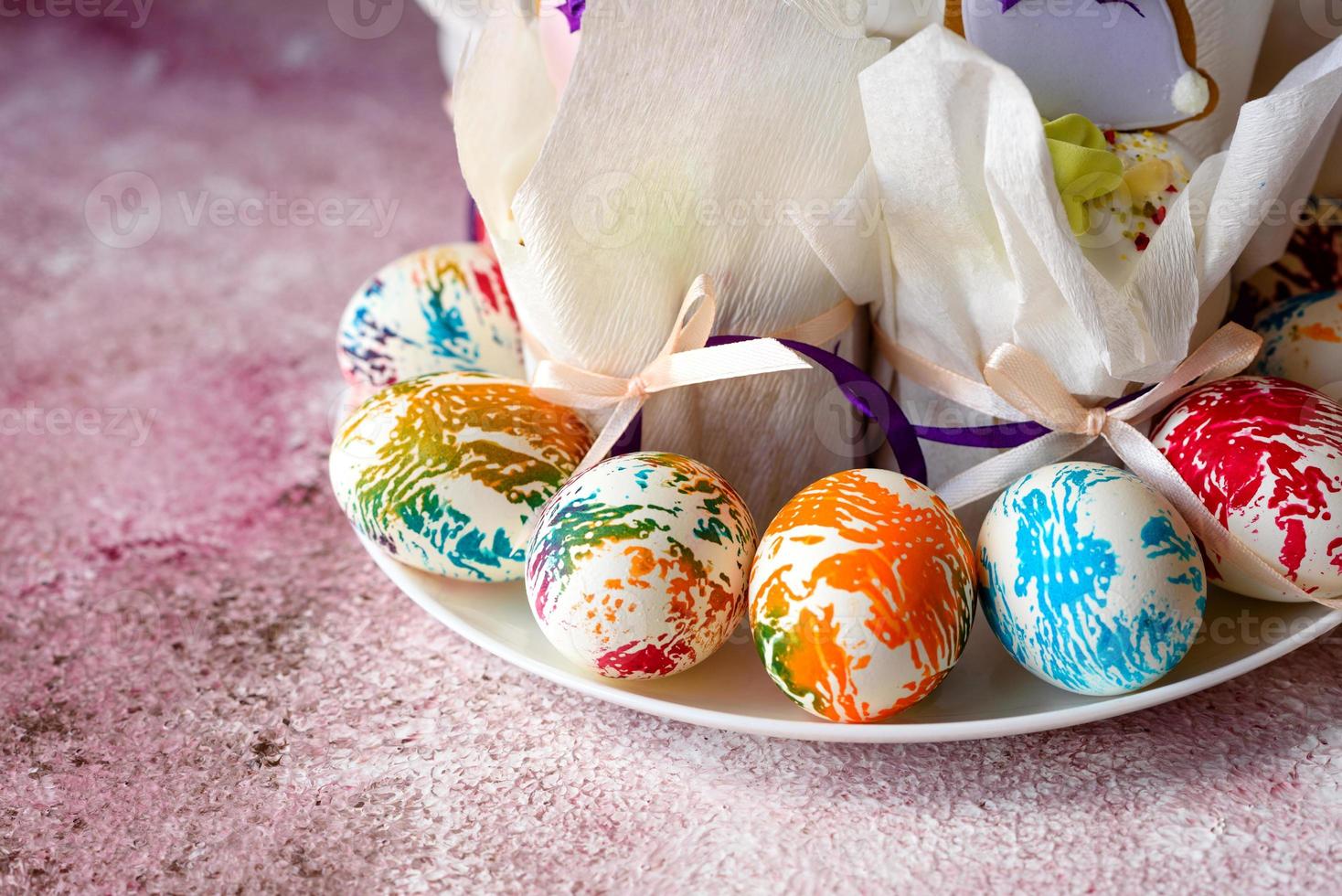 huevos de pascua de colores brillantes con pasteles de pascua foto