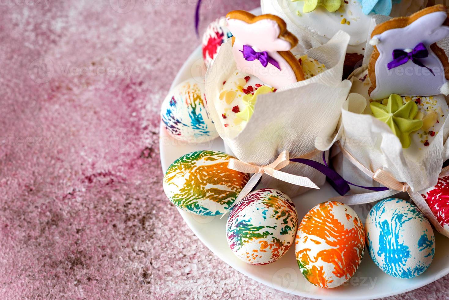 huevos de pascua de colores brillantes con pasteles de pascua foto