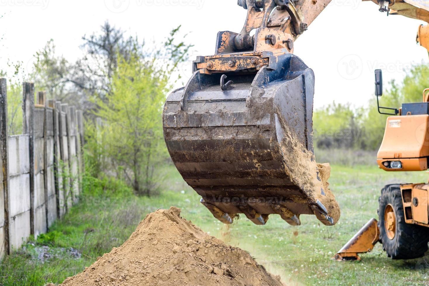 la excavadora moderna realiza trabajos de excavación en el sitio de construcción foto