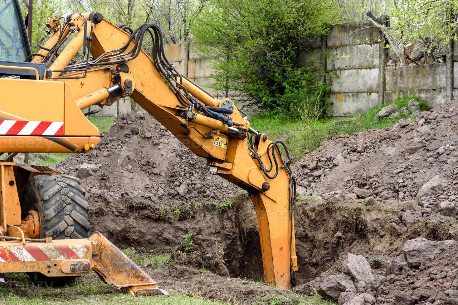 The modern excavator performs excavation work on the construction site photo