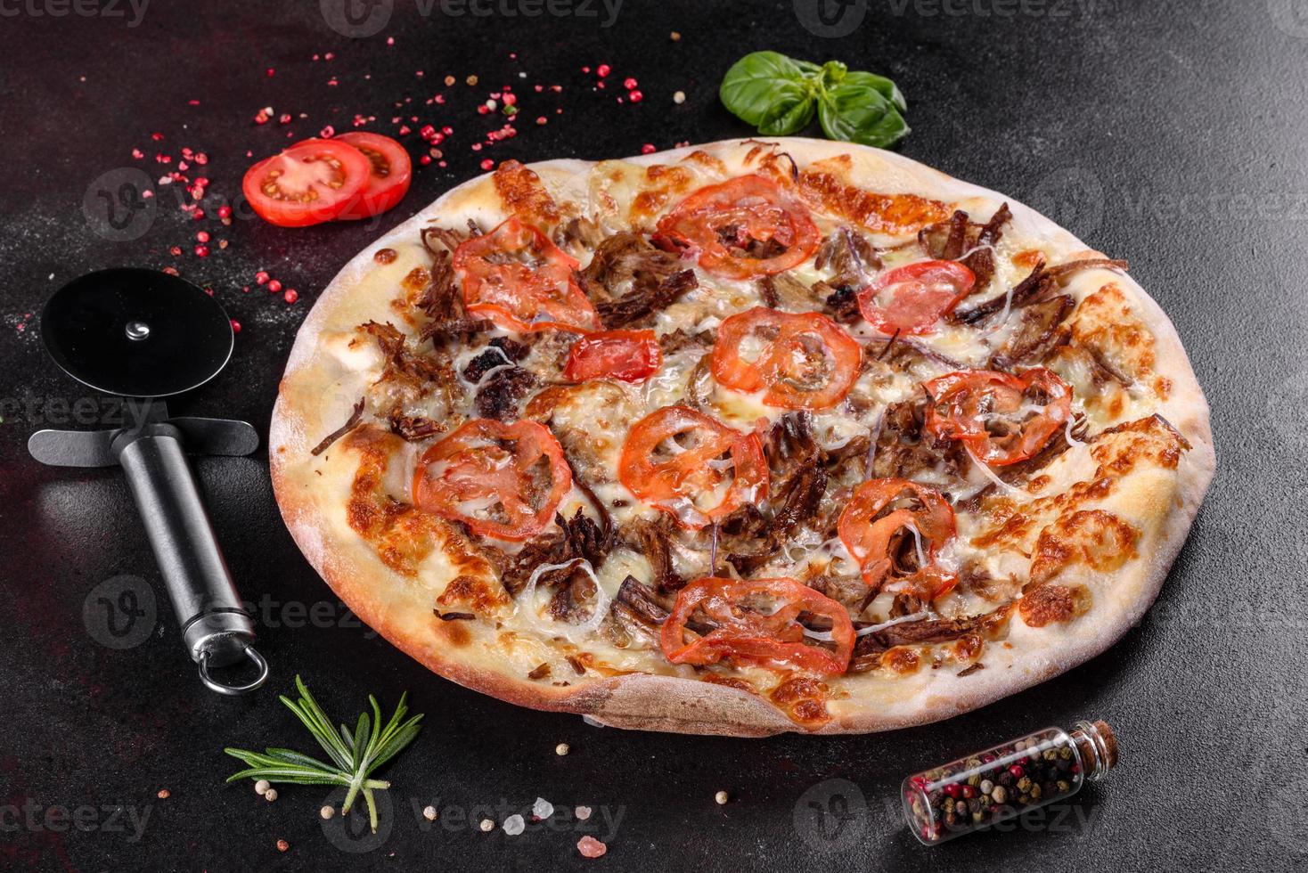 Fresh hot pizza with meat, mushrooms, cheese and tomatoes photo