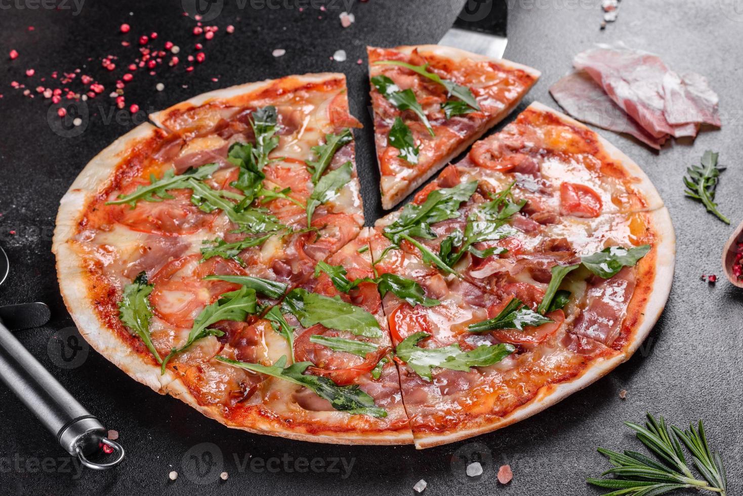 Pizza fresca al horno con rúcula, salami foto