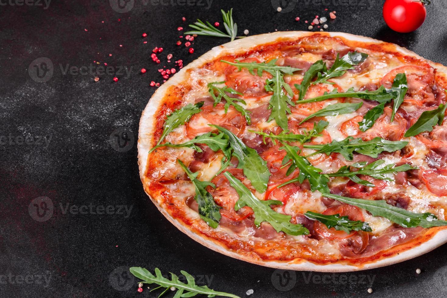 Pizza fresca al horno con rúcula, salami foto