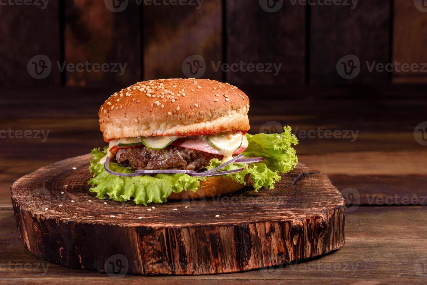 Sabrosa hamburguesa casera a la parrilla con ternera, tomate, queso foto