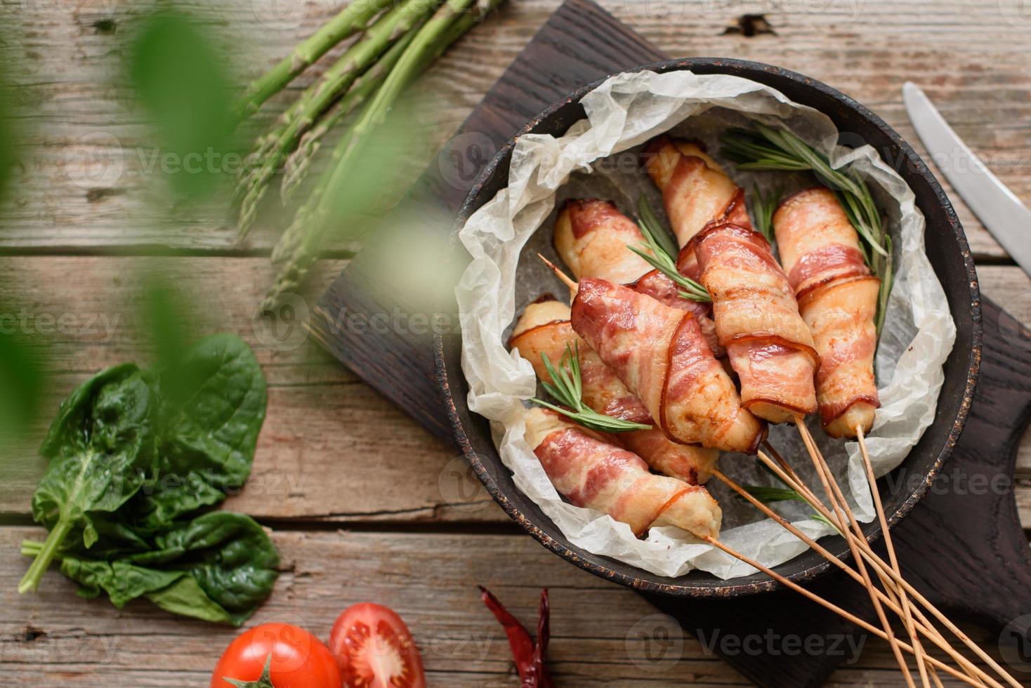 Roll with bacon and chicken mince on a stew with fresh asparagus photo