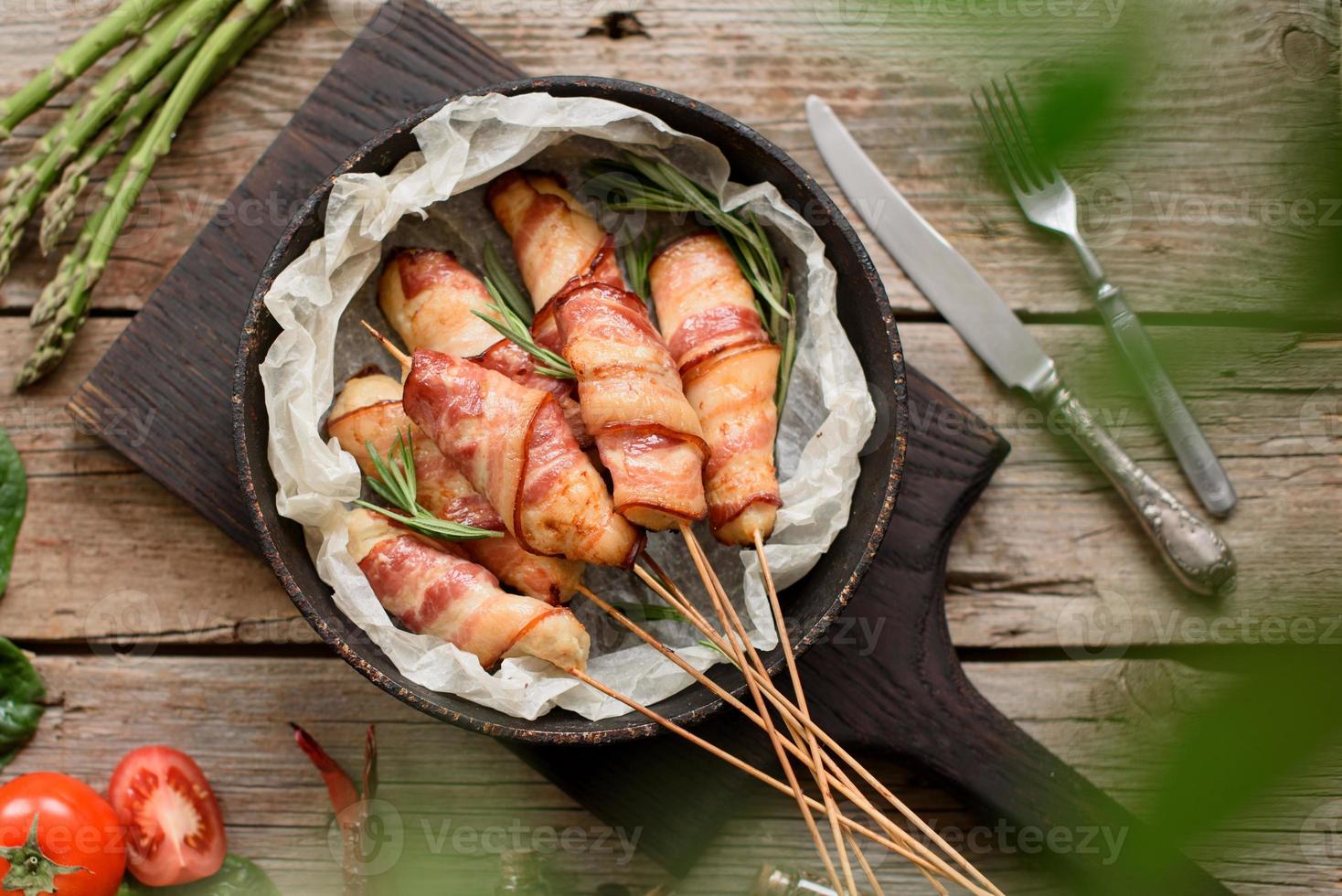 rollito con tocino y pollo picado sobre un guiso con espárragos frescos foto