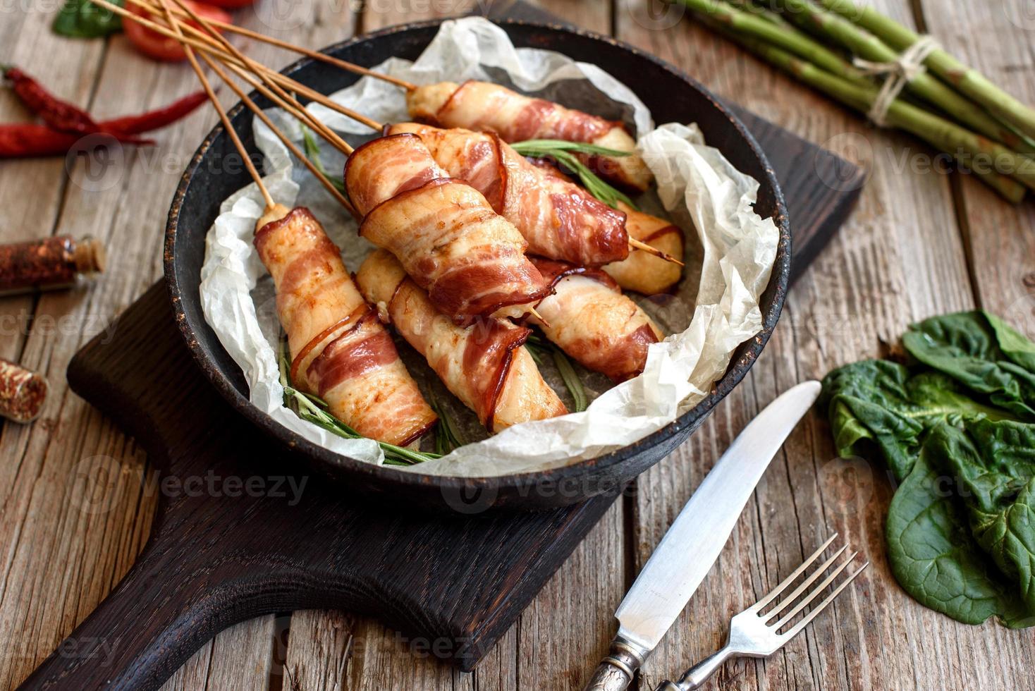 rollito con tocino y pollo picado sobre un guiso con espárragos frescos foto