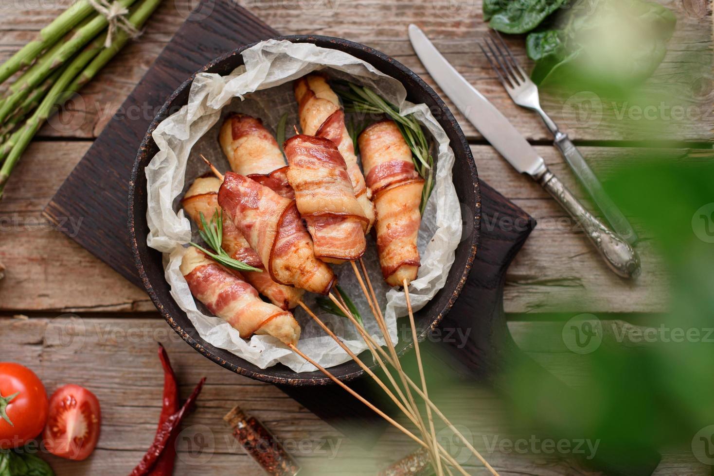 rollito con tocino y pollo picado sobre un guiso con espárragos frescos foto