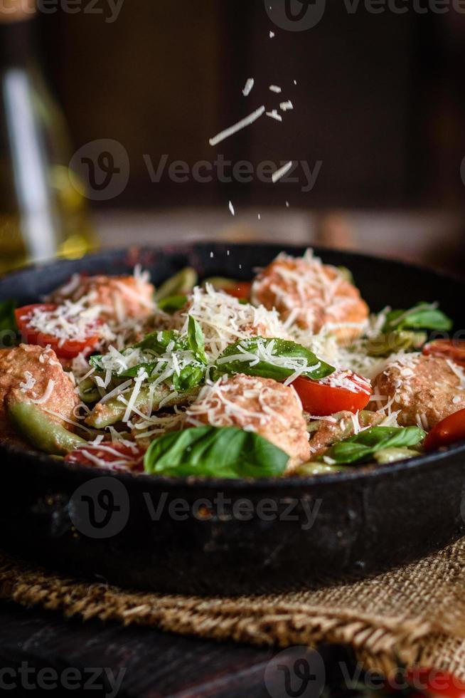 deliciosa pasta fresca con albóndigas, salsa, tomates cherry y albahaca foto