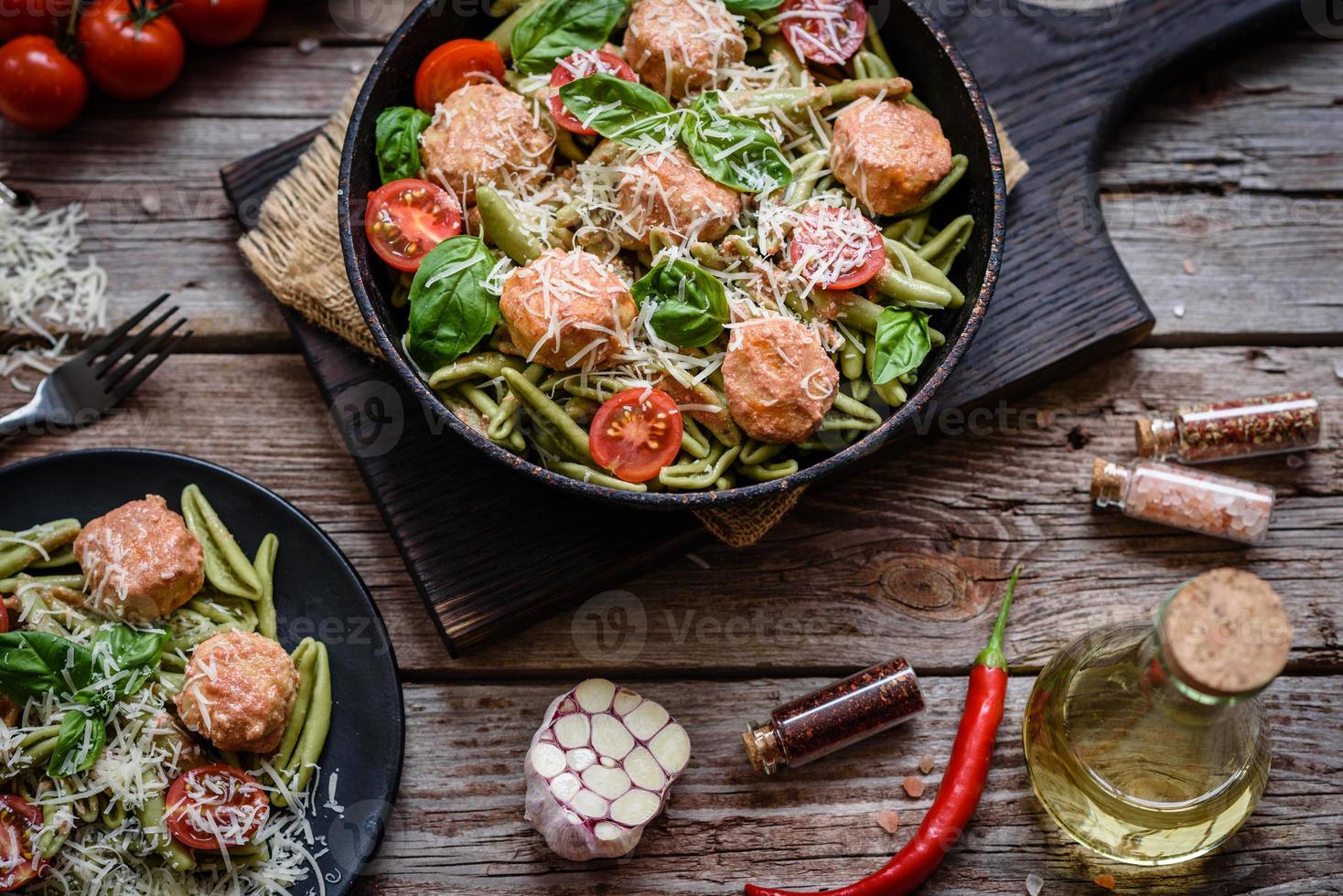 Delicious fresh pasta with meatballs, sauce, cherry tomatoes and basil photo