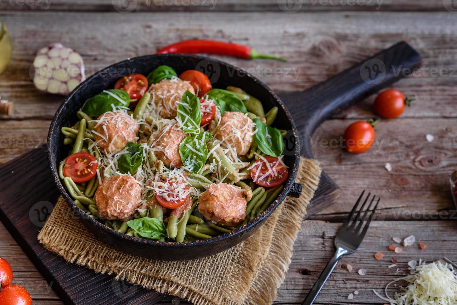 deliciosa pasta fresca con albóndigas, salsa, tomates cherry y albahaca foto