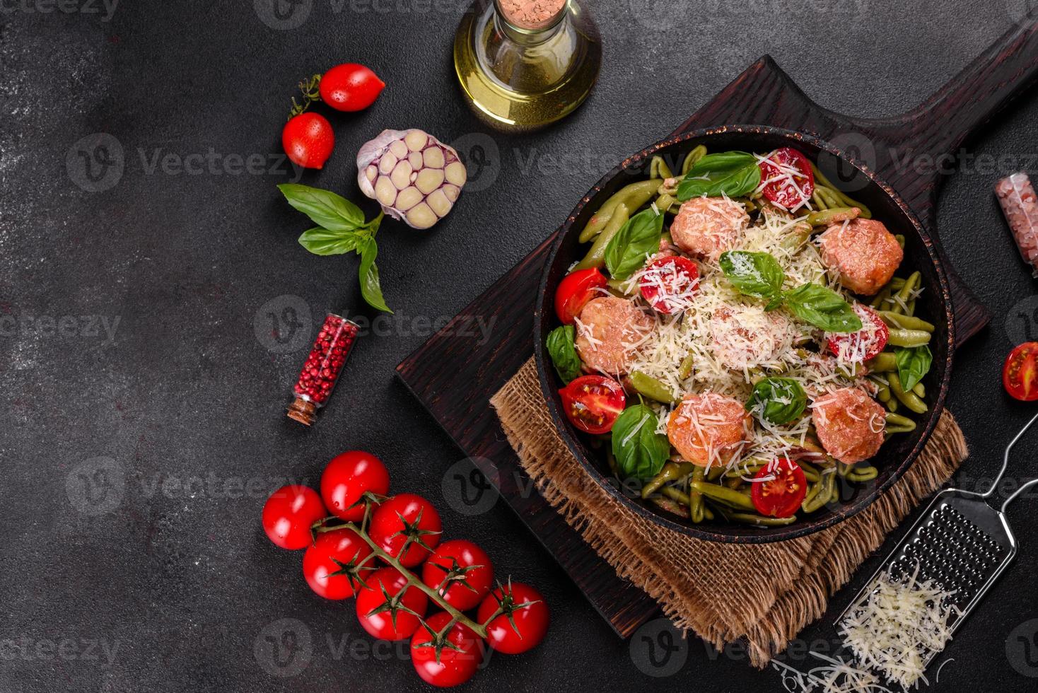 Delicious fresh pasta with meatballs, sauce, cherry tomatoes and basil photo