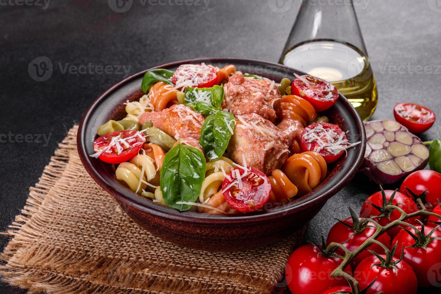 Delicious fresh pasta with meatballs, sauce, cherry tomatoes and basil photo