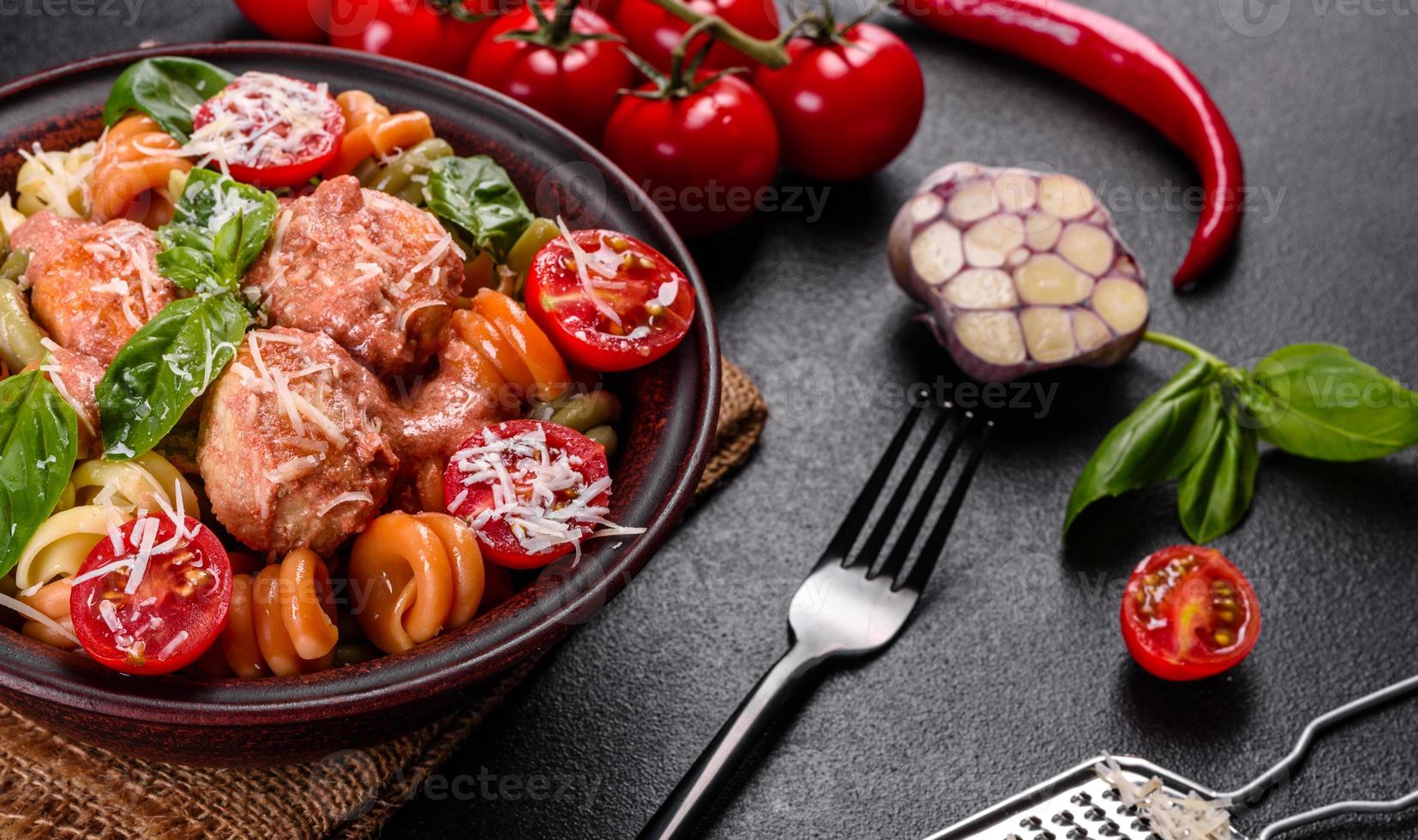 Delicious fresh pasta with meatballs, sauce, cherry tomatoes and basil photo