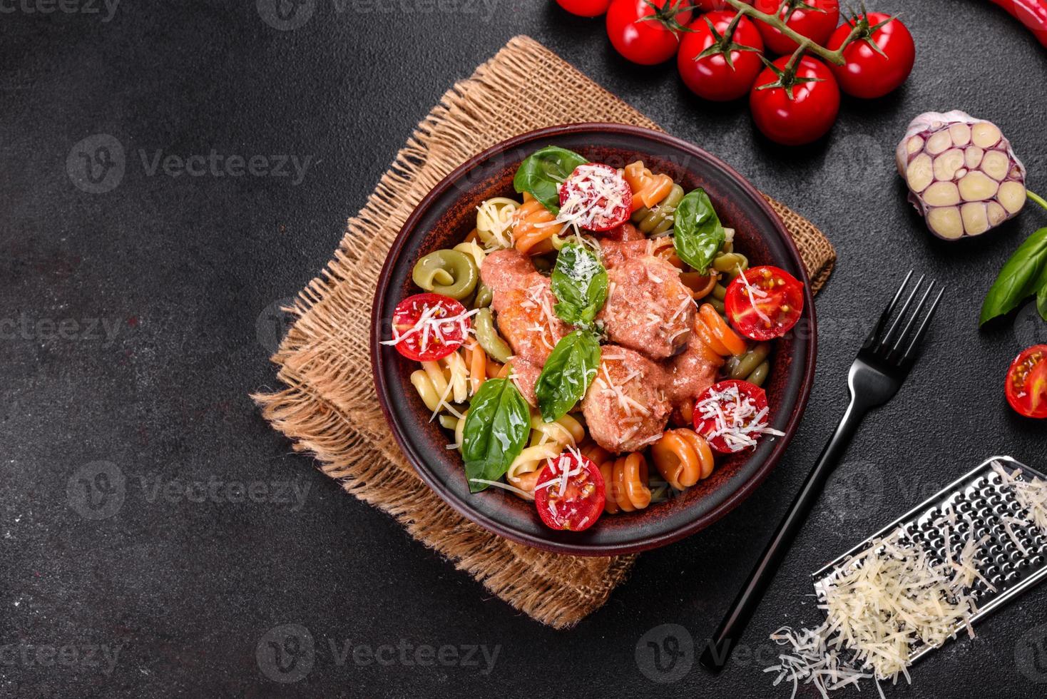 deliciosa pasta fresca con albóndigas, salsa, tomates cherry y albahaca foto