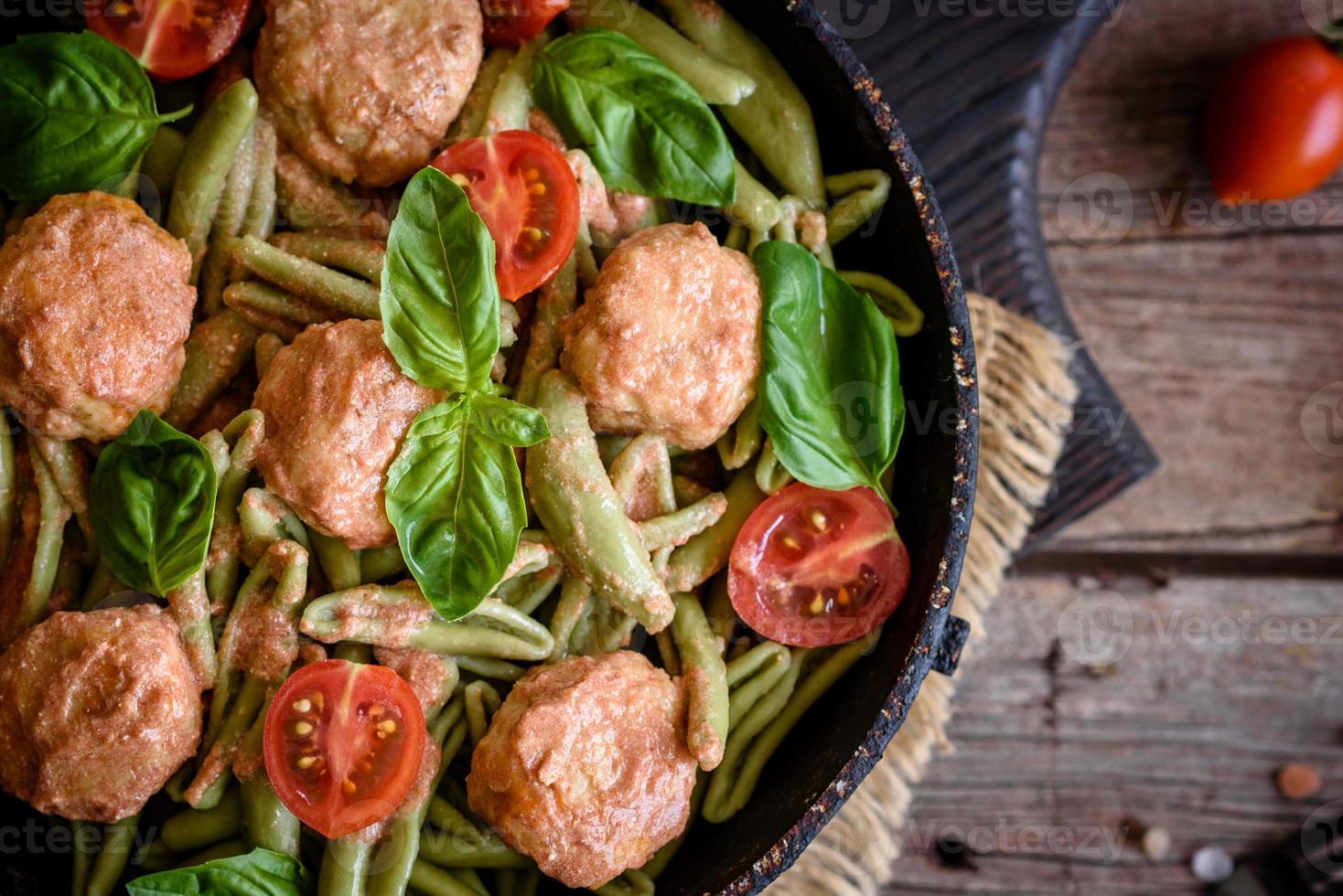 deliciosa pasta fresca con albóndigas, salsa, tomates cherry y albahaca foto