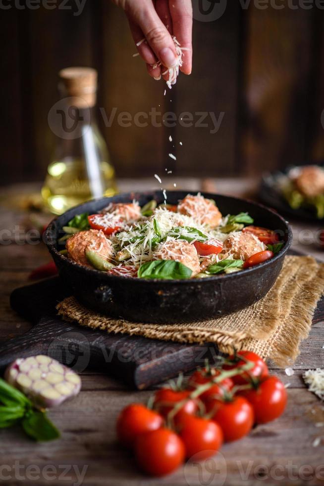 Delicious fresh pasta with meatballs, sauce, cherry tomatoes and basil photo