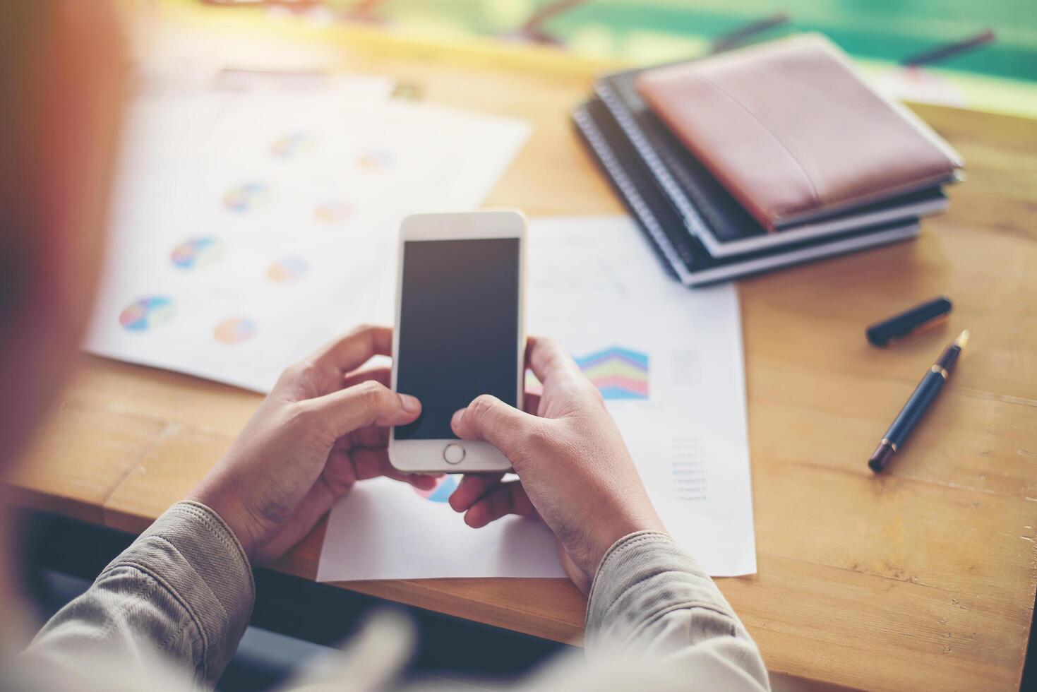 Business woman's hands working on smart phone and business information photo
