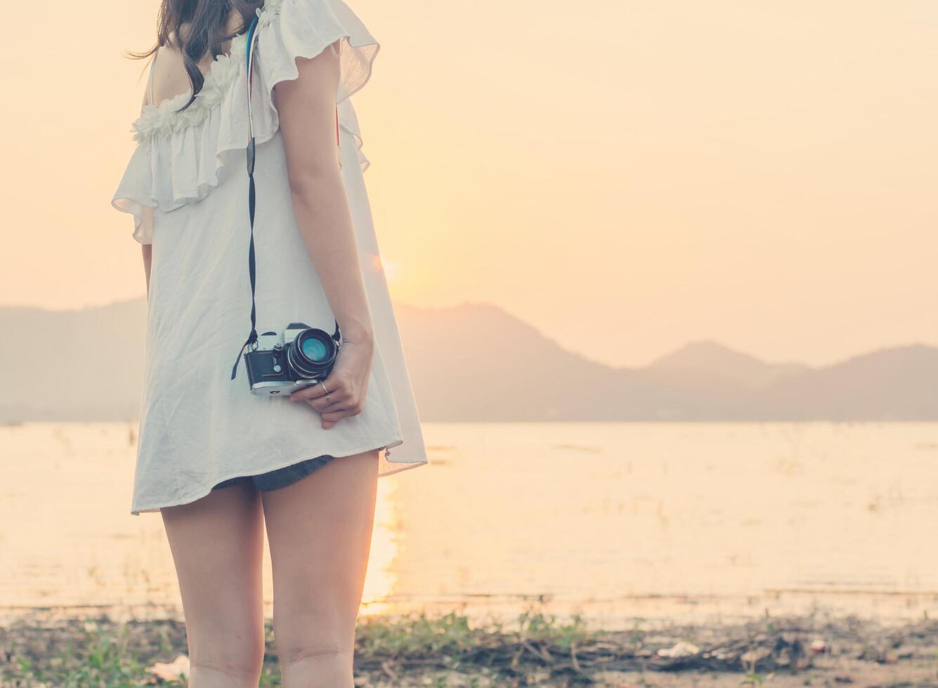 Beautiful woman photographer standing hand holding a retro camera photo
