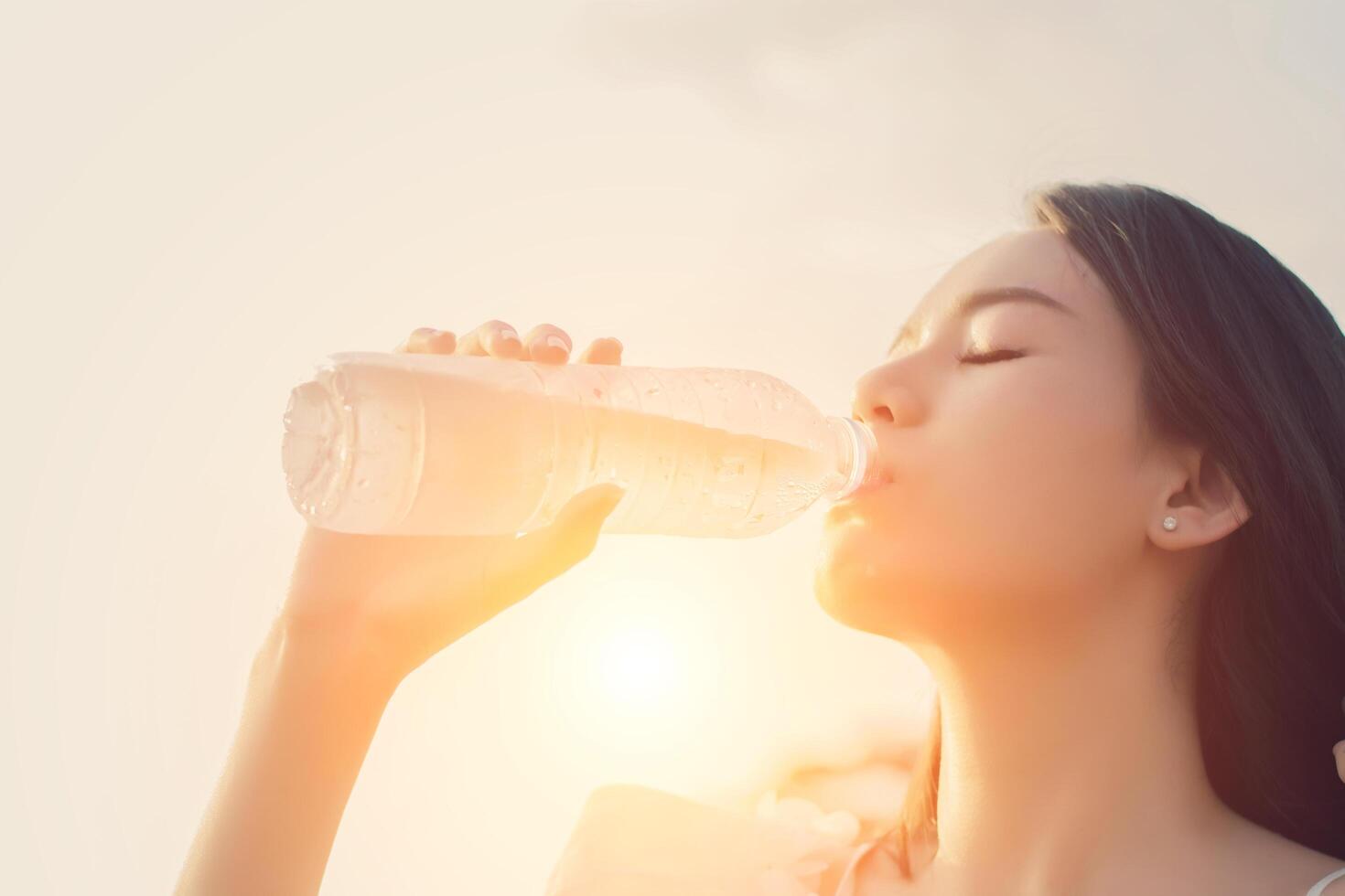 Woman drinking water for thirst, in a dreamy soft style photo