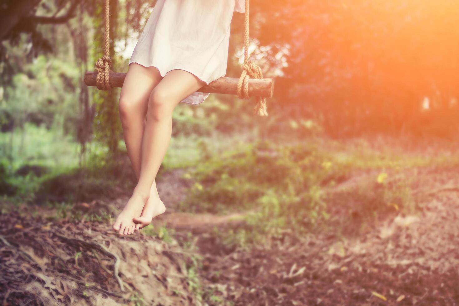 Beautiful women sitting on swings and very happy photo