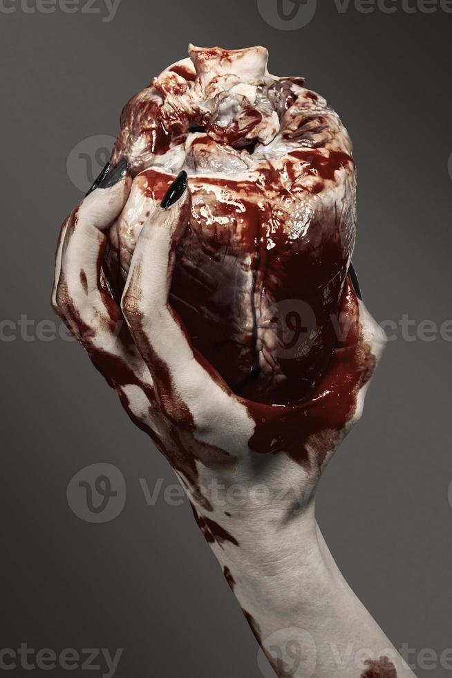 Female hand holds a human heart in his hands photo