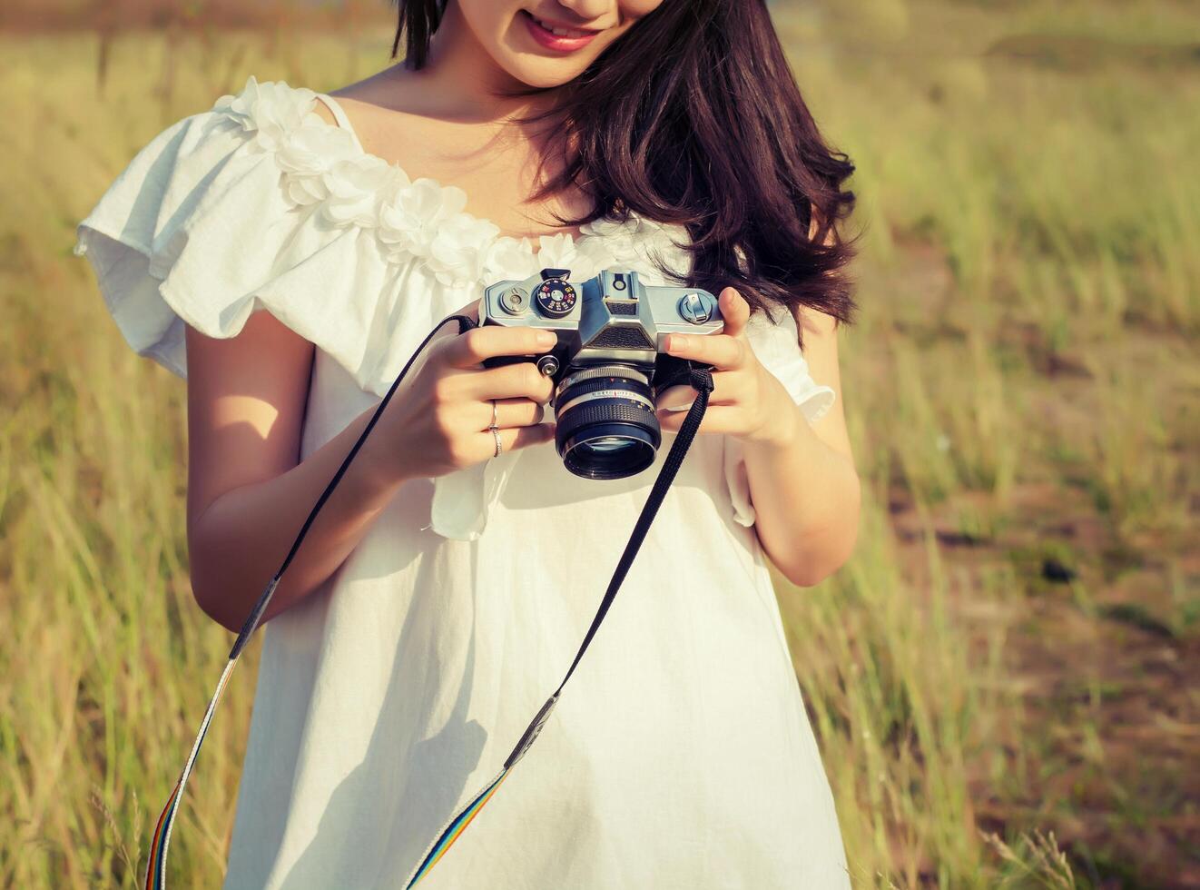 vintage de fotografía de mujeres mano de pie sosteniendo una cámara retro. foto