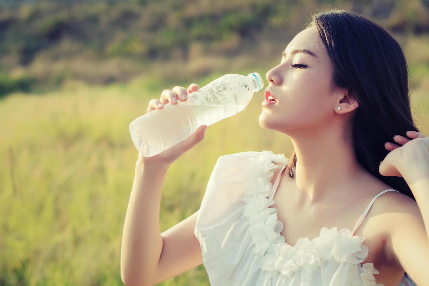 mujer bebe agua para la sed, sueña estilo suave. foto