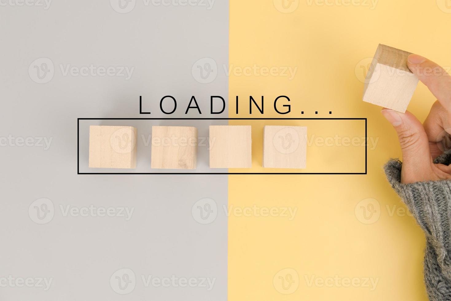 Hand putting wooden cube block in progress loading bar photo