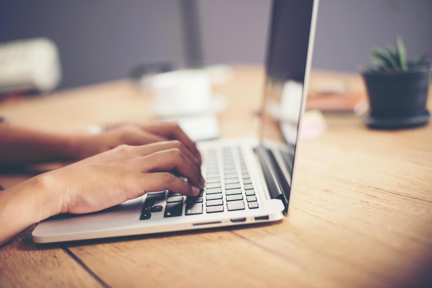 Close-up woman hands typing on laptop in office. photo