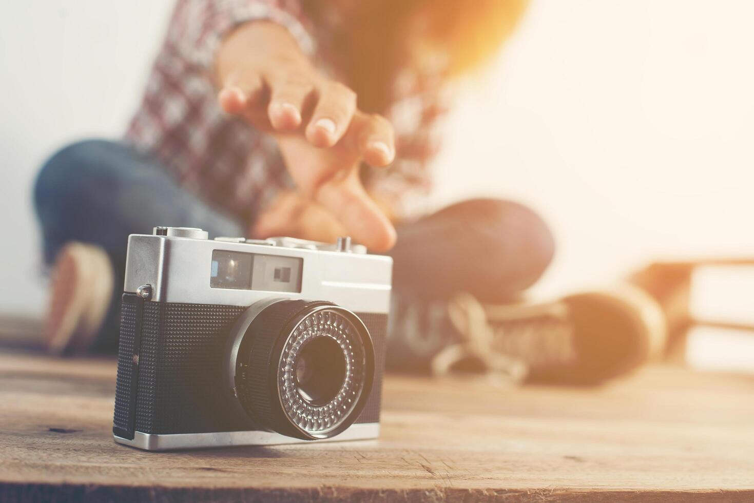 Young hipster woman hand reach out for catch retro camera. photo