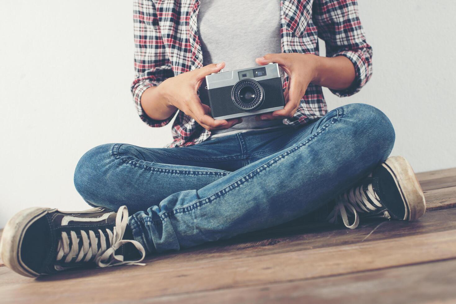 mujer joven hermosa hipster con una vieja cámara retro. foto