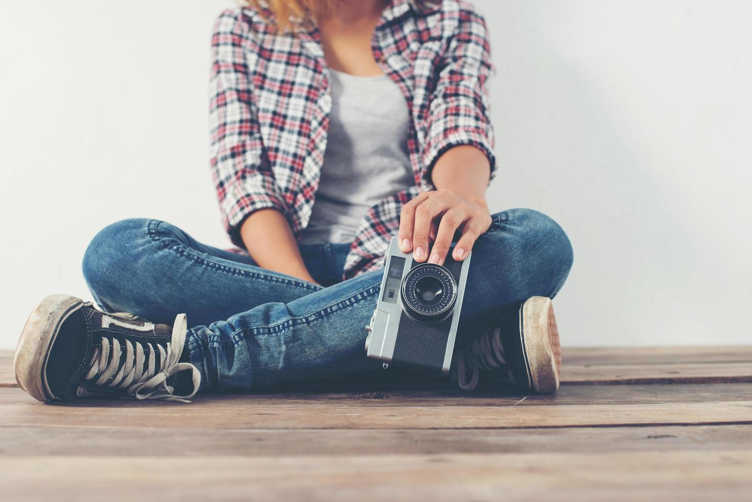 Young hipster photographer woman taking photo and look at camera