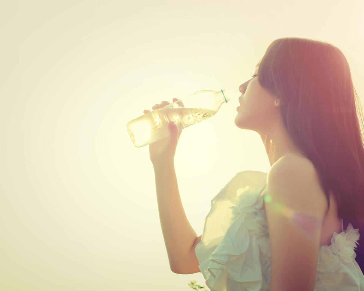 mujer bebe agua para la sed, sueña estilo suave. foto