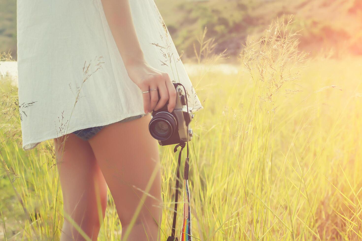 Vintage woman photographer standing hand holding retro camera photo